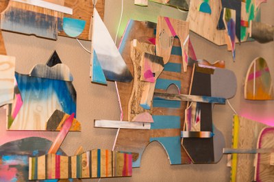 A close up look at a part of the Shapeshifters multimedia, 3D sculpture by Karl Hofmann featuring painted sections of various-sized wood pieces.