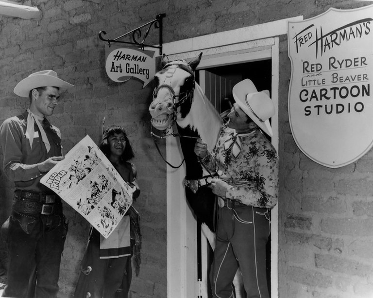 A black and white photo featuring a small group of people standing around a horse that's standing in the doorway of a building.