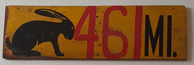 A mile marker sign with an illustration of a jackrabbit and the text 461 mi.
