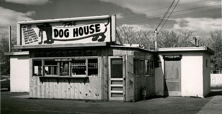 A vintage photo of the Dog House restaurant building with the iconic dachshund mascot on the sign.