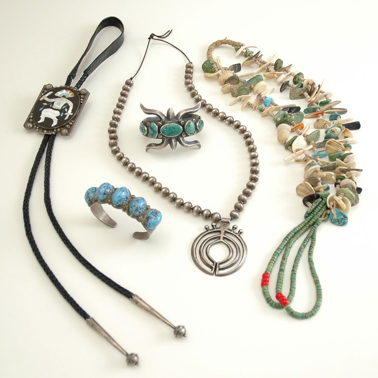 A selection of Native American jewelry on displayed on a white table.