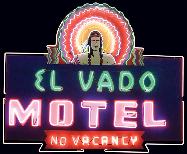 The vintage El Vado Motel neon sign in bright teal, pink, and orange colors.