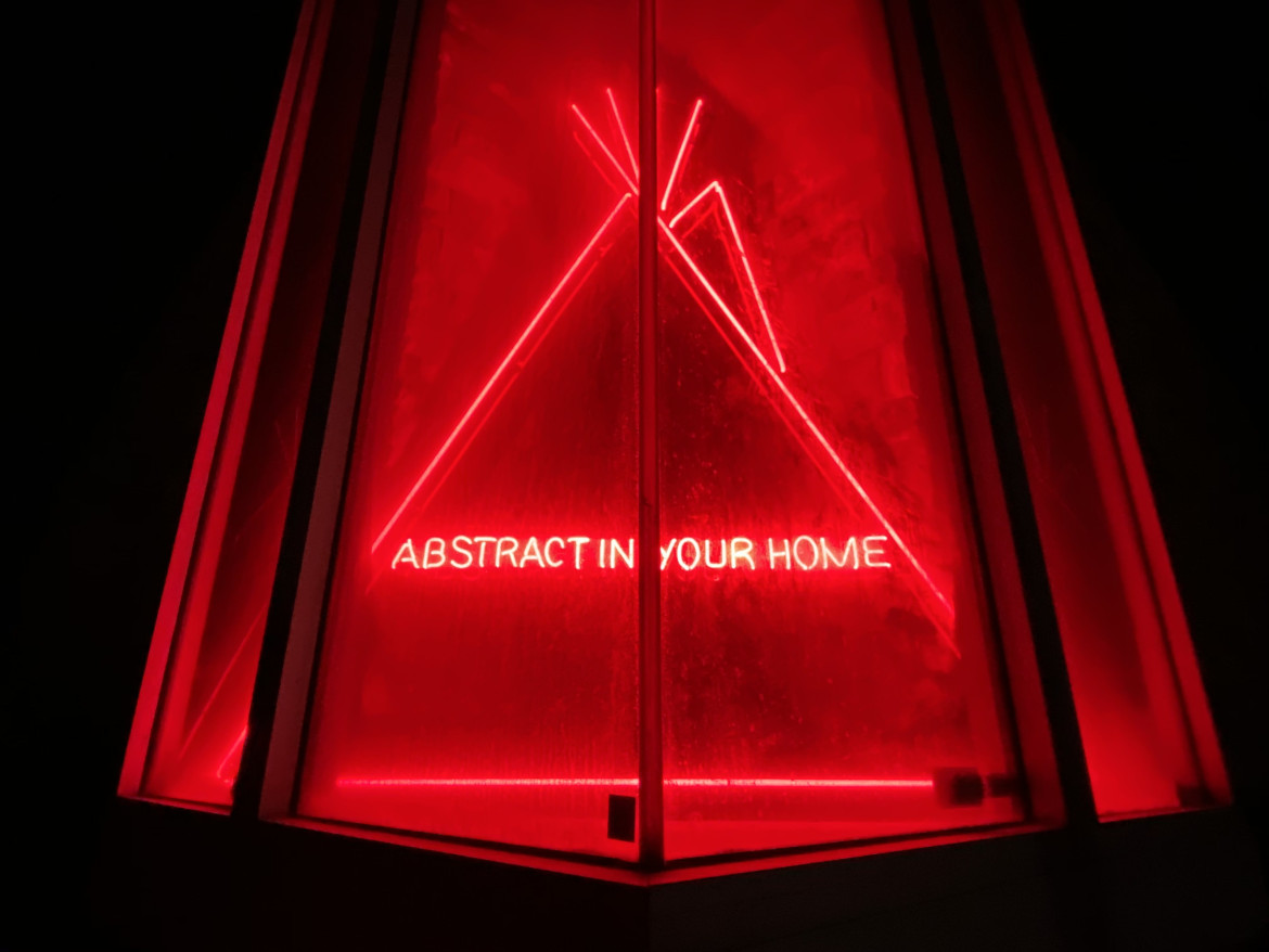 Red light glass tubing with neon writing ABSTRACT IN YOUR HOME