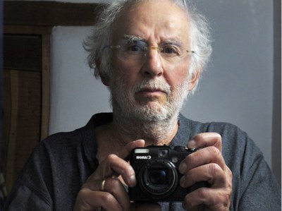 Danny Lyon self portrait holding a camera.