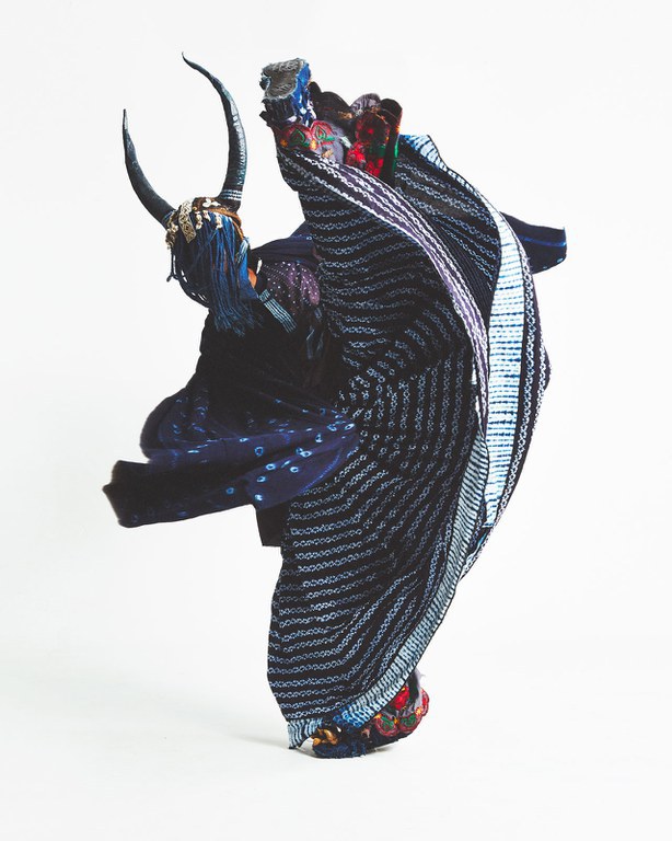 A hand-woven indigo-dyed cotton textile by Habibou Coulibaly, courtesy of L’Aviva Home; indigo-dyed cotton brocade, printed cotton, machine embroidery from Oaxaca, decorated sneakers, natural fiber basket, buttons, fabric-maché, leather, character from Intervention: Indigo, photo by Rene Cervantes, courtesy of the artist