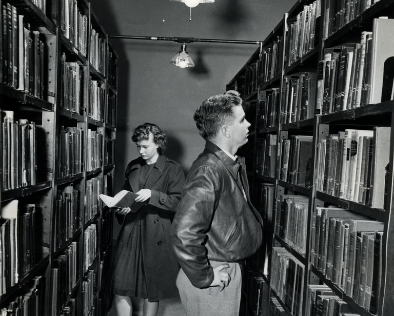 Library with man and woman looking at book shelves