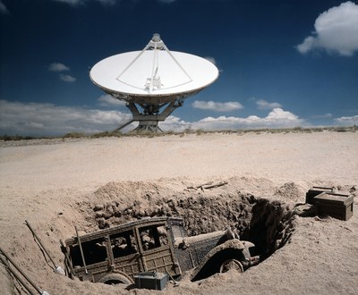The VLA and a partially buried antique vehicle.