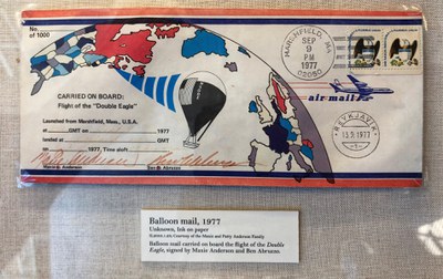 An envelope with illustrations of the planet and a hot air balloon.