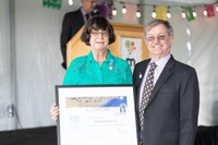 Two people holding up a plaque.