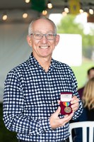 A man holding an medal smiles at the audience.