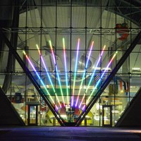 A multi-colored neon light display in the large glass window of the Balloon Museum.