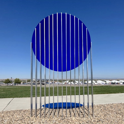 A sculpture featuring a large blue circle sliced into over a dozen segments held up on metal poles.