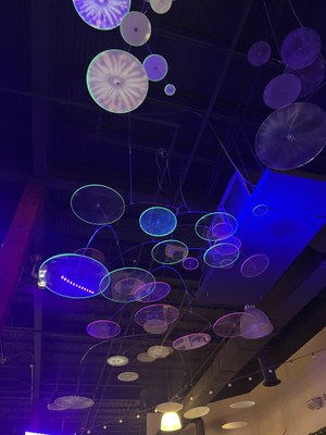 Suspended, circular mobile with mutli-colored spherical projections.