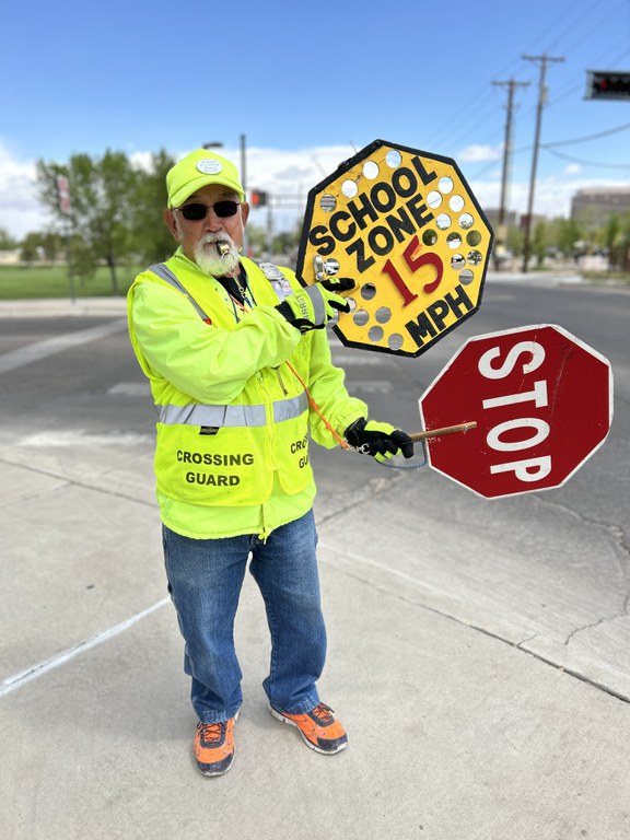 Crossing Guard holding signs to slow traffic down