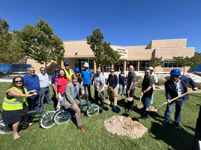 Various city leaders and community members posing with shovels and lowrider bicycles to celebrate the next phase of Joan Jones Community Center