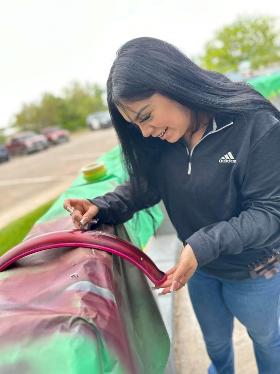 Student painting lowrider bicycle