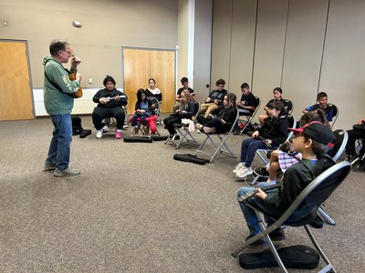 A group of students learning to play the ukulele.