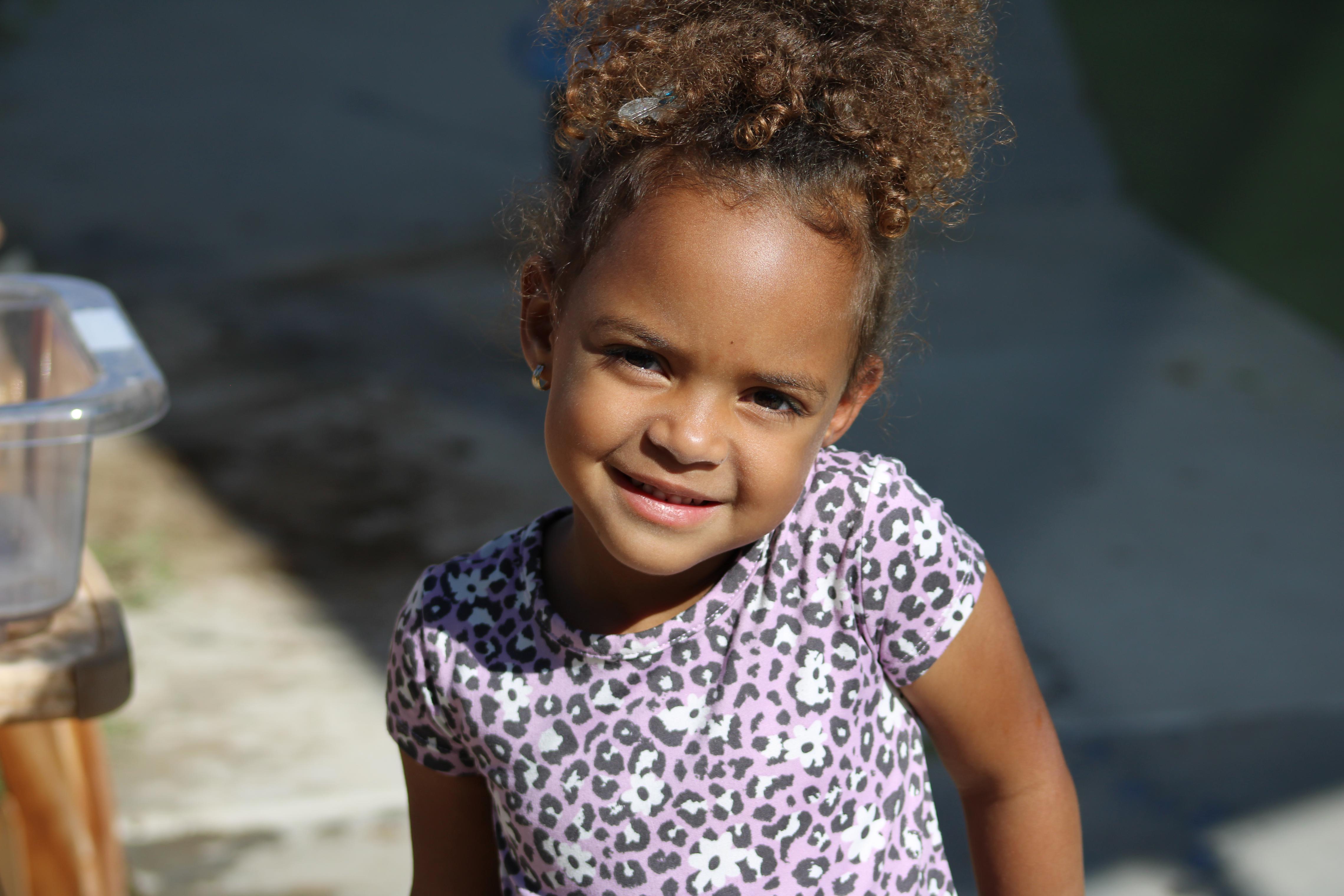 Pre k student smiling at camera.