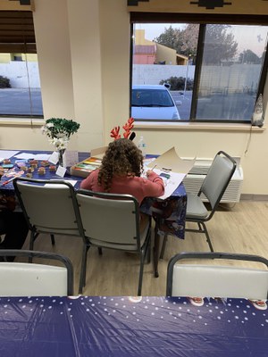 Photo of kid sitting at table coloring