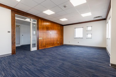 Photo of room in education building with wood paneling and blue carpet tile flooring