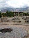 Wooden stadium seating around a fire pit.