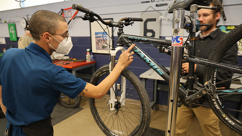 Two people fixing on a bicycle.