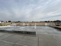 Updated image of West Gate Spraypad from 2024 depicting the new layout of West Gate with multiple geysers spraying upwards.