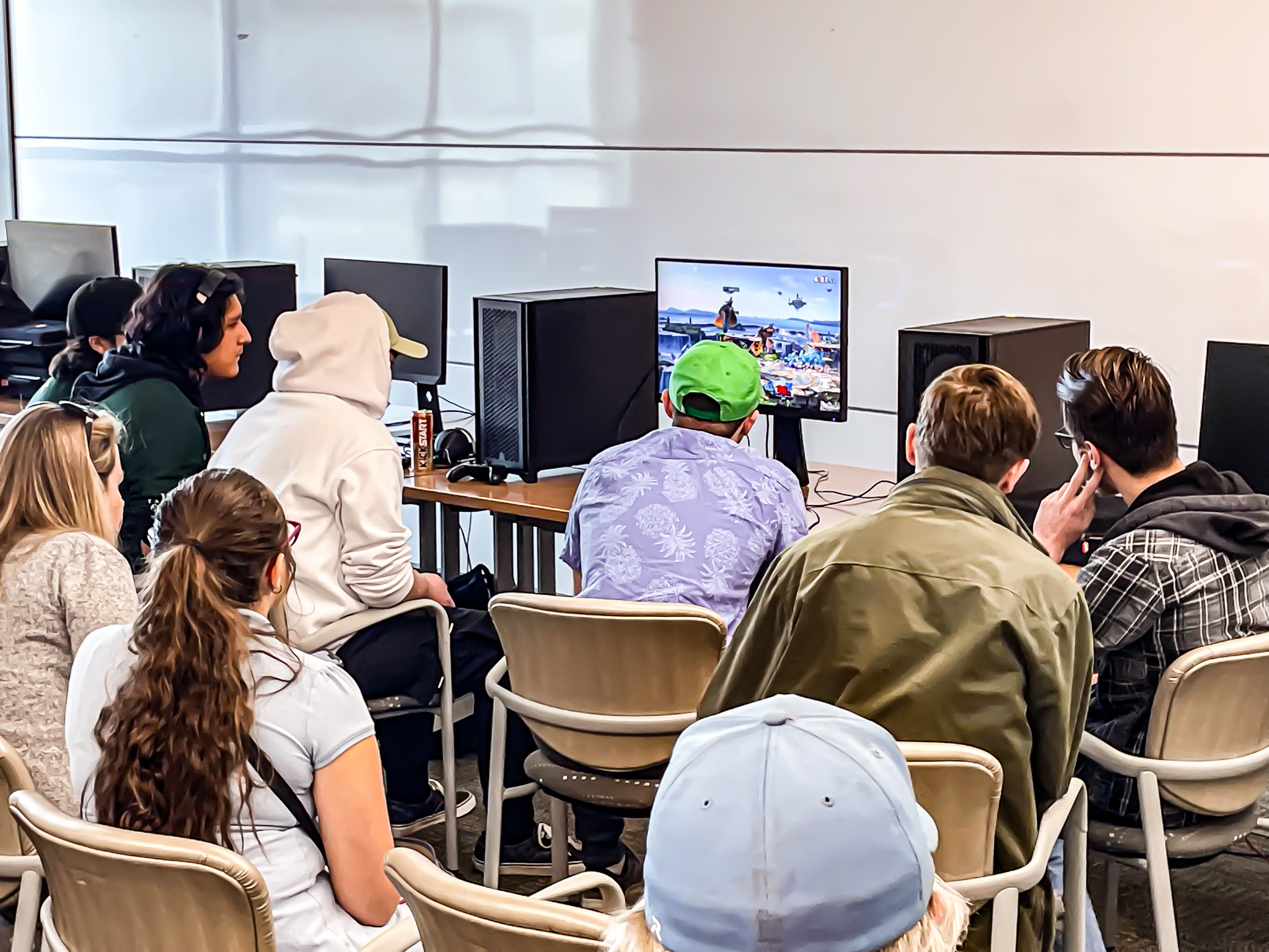 Families and friends watch from behind as players compete in esports competition.