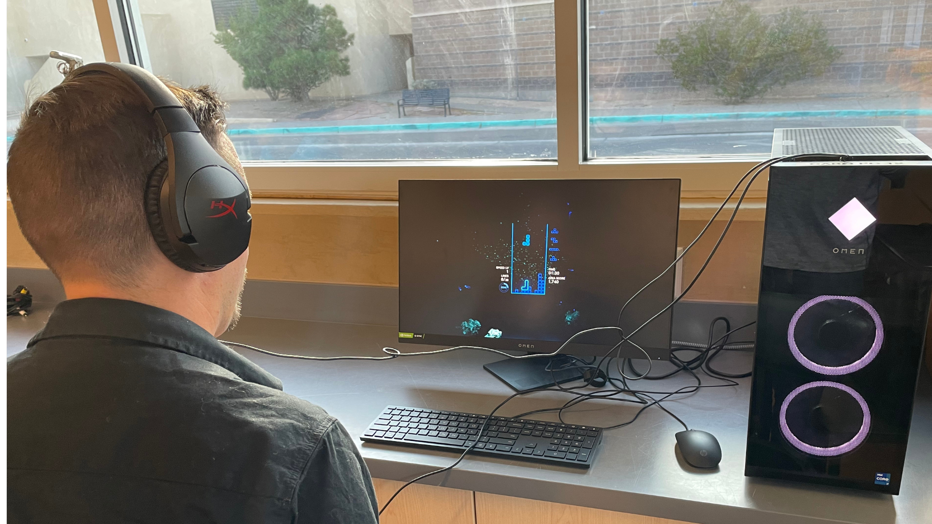 A man sits at a computer to play the newest Tetris game!