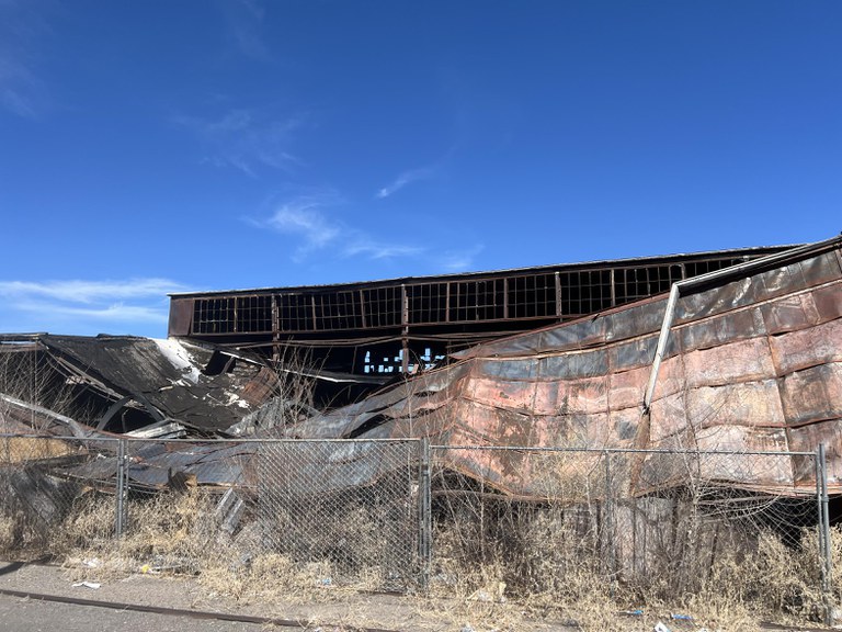 A partially collapsed building that was involved with a fire that is in need of repair or demolition.