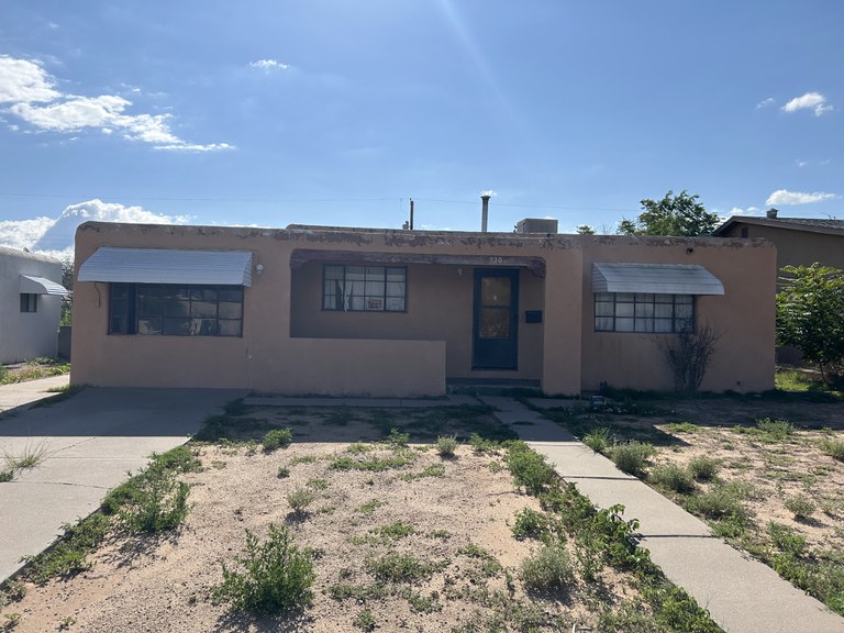 A dilapidated adobe house in need of repair.