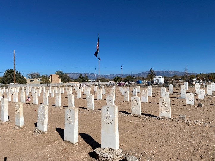 A cemetery with rows of white headstones